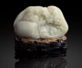 LYON & TURNBULL FINELY CARVED WHITE JADE 'RED CLIFF' BOULDER